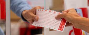 Someone receiving a lottery slip from a cashier